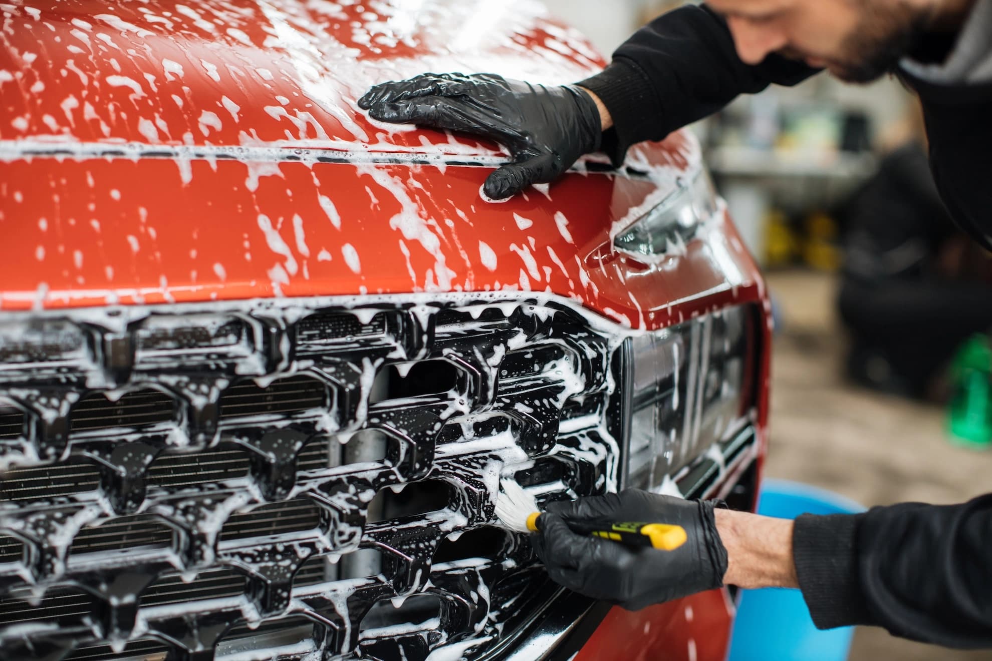 Auto detailer wearing protective gloves while cleaning a vehicle