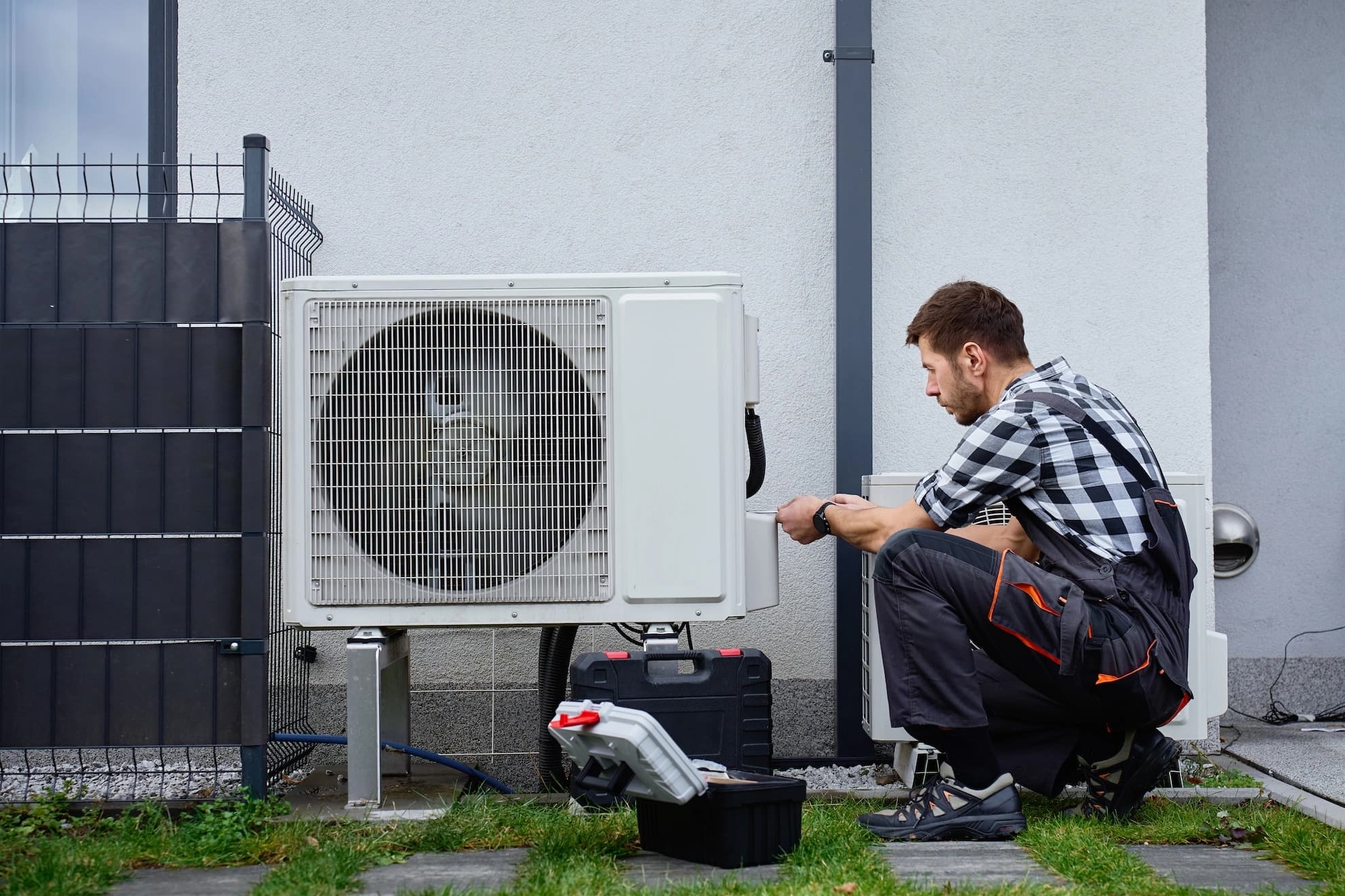 HVAC technician servicing an outdoor air-conditioning unit