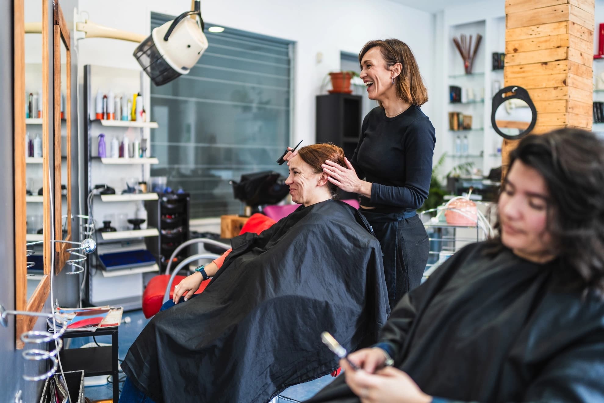 Hairdresser styling a client in a bright salon